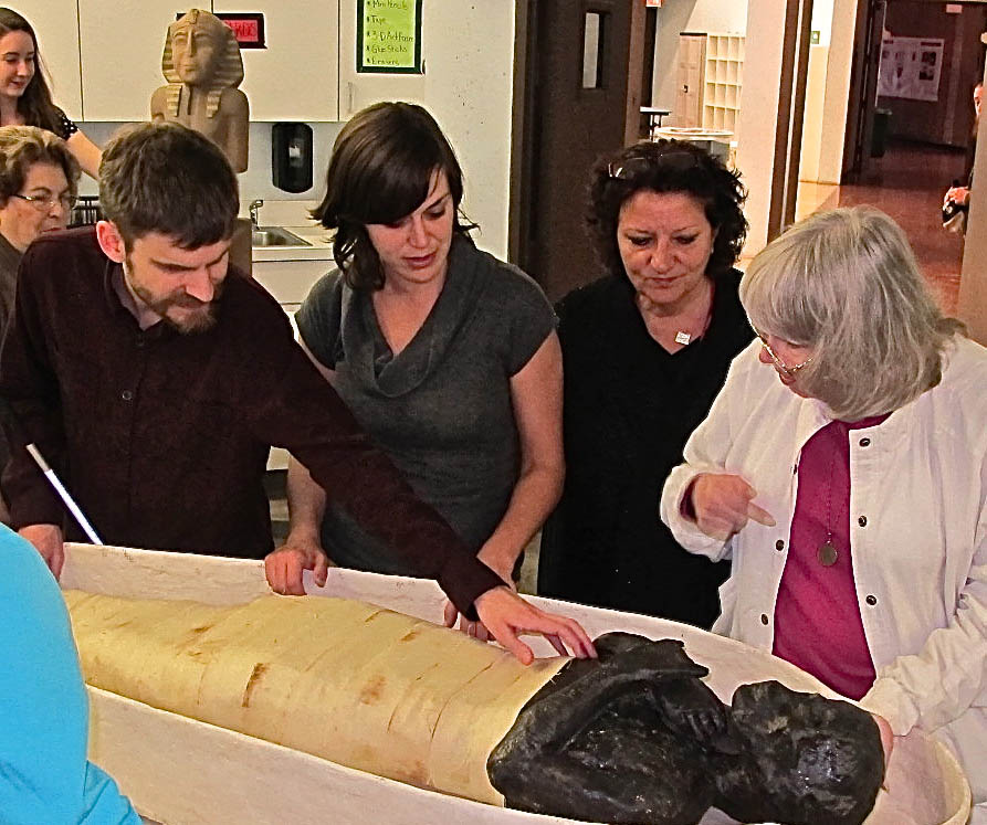 Maria, second from the left, showing members of Philly Touch Tours' team the replica mummy